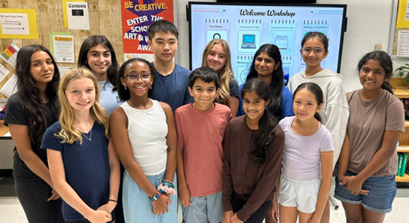 Students standing in front of white board.