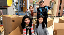 Students standing in front of boxes.