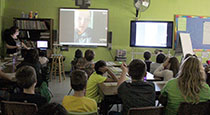 Students watching a video on large TVs.