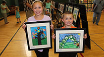 Students holding their art work.