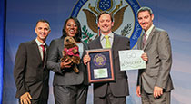 Warren Administrators holding a plaque and a go woodchucks sign.