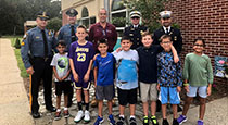 Students standing with police and military personnel.