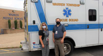 Nurse standing in front of ambulance.