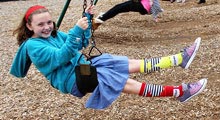 Girl swinging on a swing.