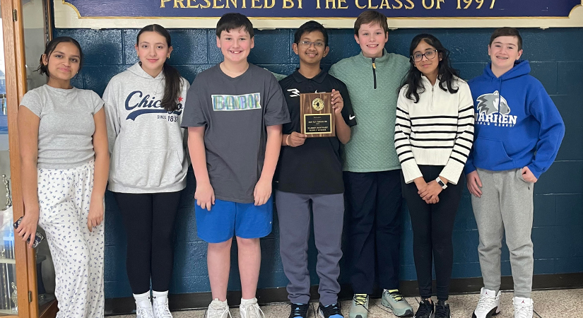 Students holding up a plaque